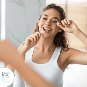 A woman flossing in the mirror