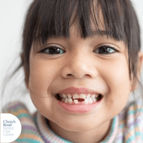 A close up of a child smiling with gappy teeth